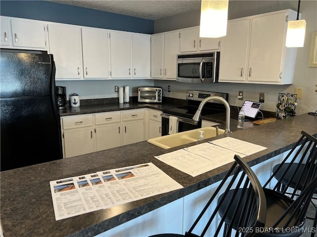 kitchen featuring pendant lighting, a breakfast bar area, white cabinets, and appliances with stainless steel finishes