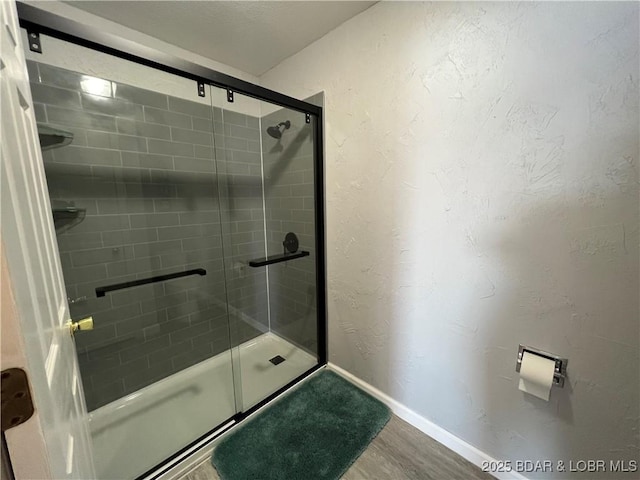 bathroom with hardwood / wood-style floors and walk in shower