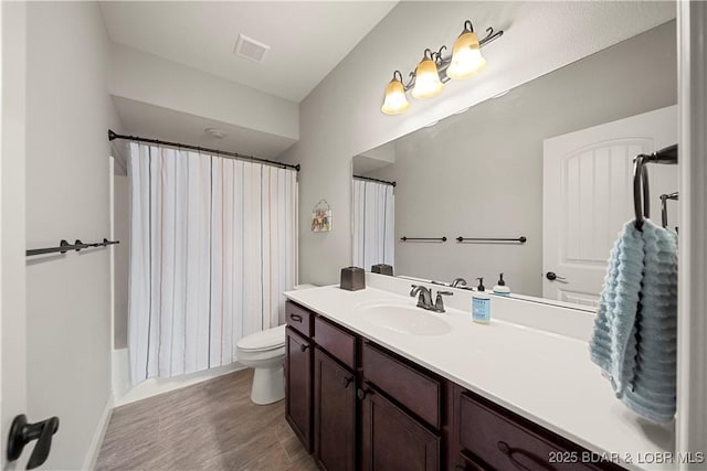 full bathroom with vanity, hardwood / wood-style floors, shower / tub combo, and toilet