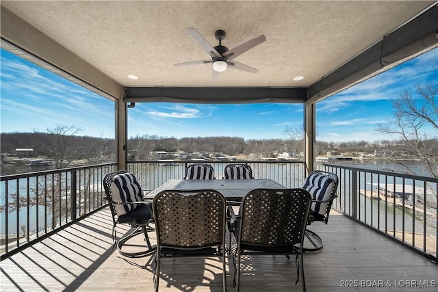 deck with a water view and ceiling fan