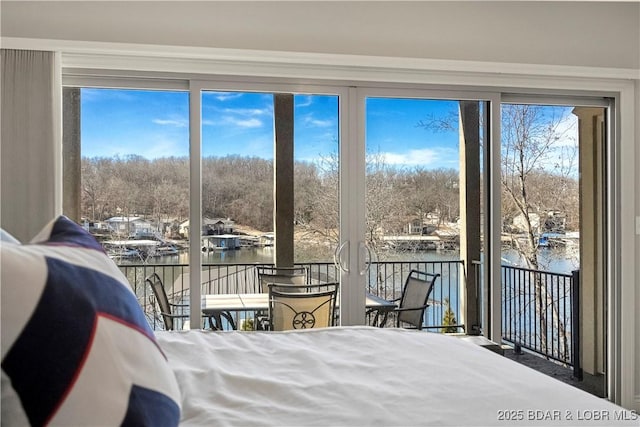 bedroom featuring a water view and access to outside