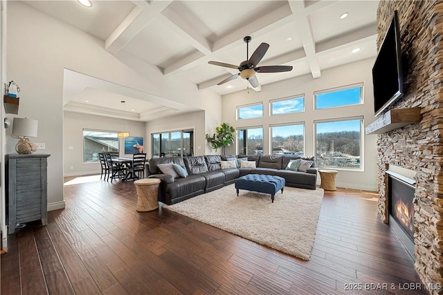 living room with coffered ceiling, a fireplace, dark hardwood / wood-style flooring, and beam ceiling