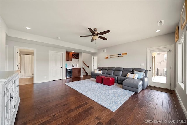 living room featuring dark hardwood / wood-style floors, wine cooler, and ceiling fan