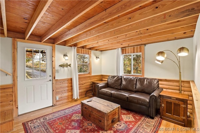 living room with beam ceiling, wood-type flooring, and wooden ceiling