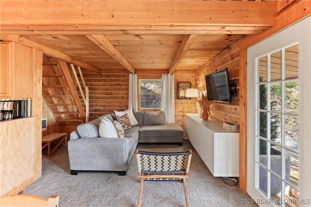 carpeted living room with wooden walls, wood ceiling, and beam ceiling