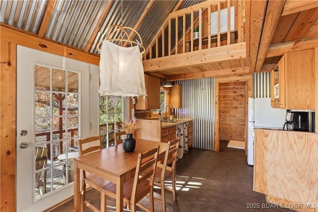 tiled dining room with sink and beam ceiling