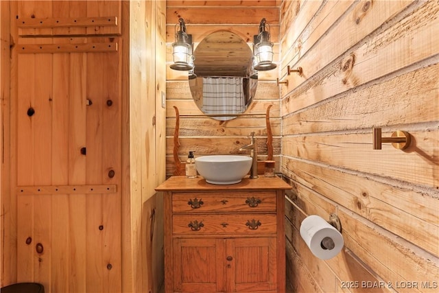 bathroom with vanity and wooden walls