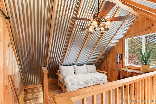 sitting room with lofted ceiling and wood walls