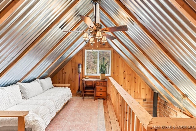 living area with vaulted ceiling and wooden walls