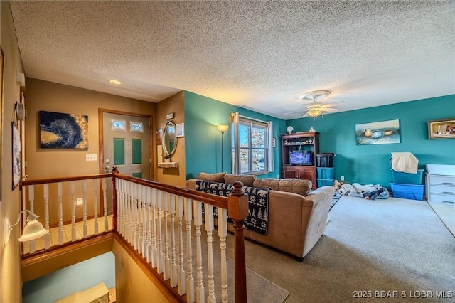 living room featuring light carpet, a textured ceiling, and ceiling fan