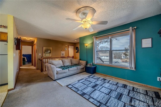 living room featuring ceiling fan, carpet floors, and a textured ceiling