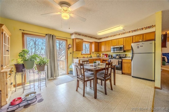 dining area featuring ceiling fan and a textured ceiling