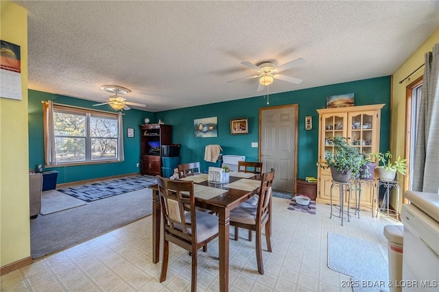 dining area with ceiling fan and a textured ceiling