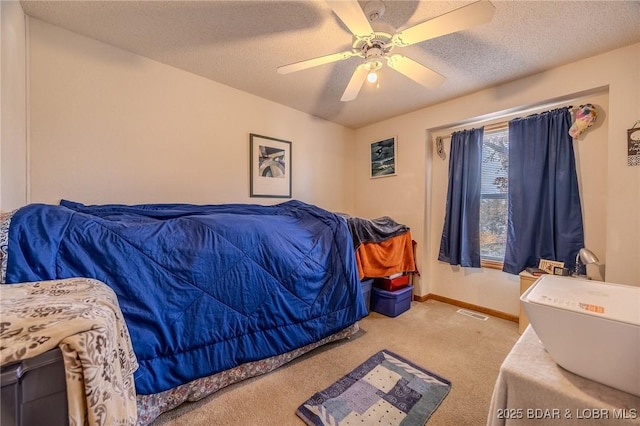 bedroom featuring ceiling fan, light colored carpet, and a textured ceiling