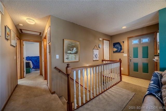 hall featuring light colored carpet and a textured ceiling