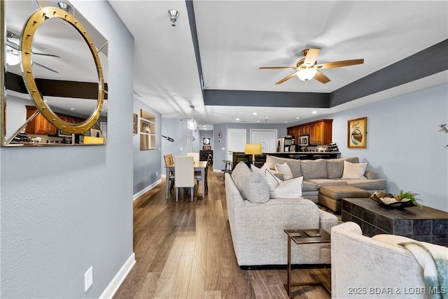 living room with ceiling fan and dark hardwood / wood-style flooring