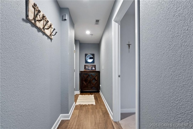 hallway with hardwood / wood-style floors