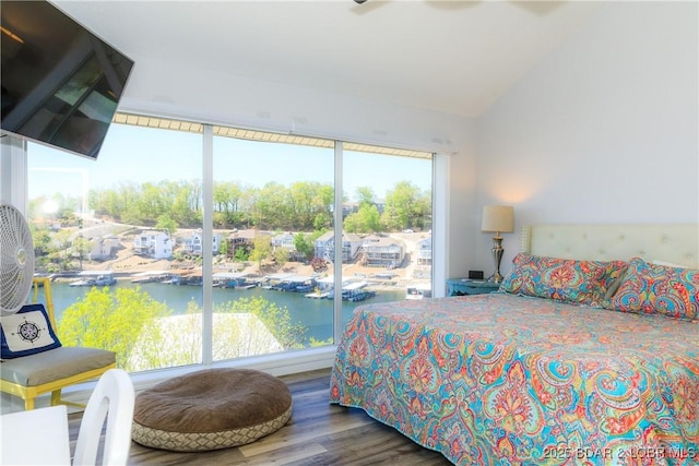 bedroom featuring wood-type flooring, a water view, and lofted ceiling