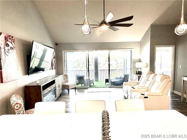 living room with dark wood-type flooring, ceiling fan, and vaulted ceiling