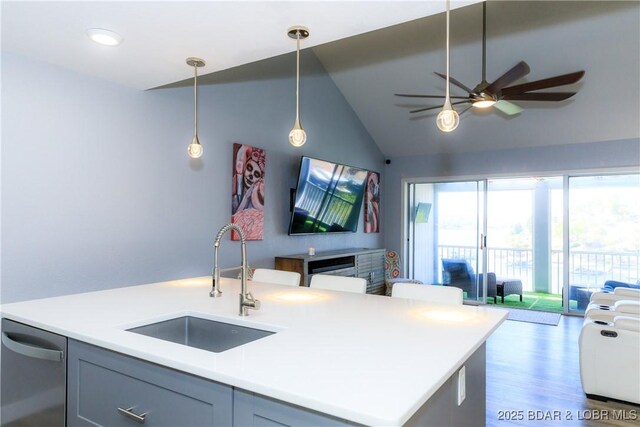 kitchen featuring pendant lighting, sink, dishwasher, a center island with sink, and vaulted ceiling