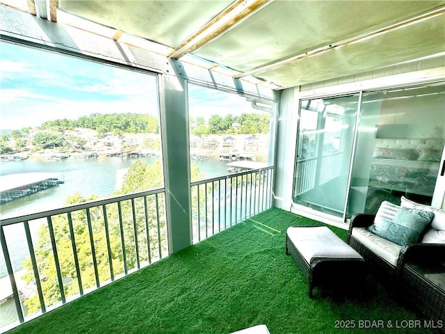 sunroom / solarium featuring a water view