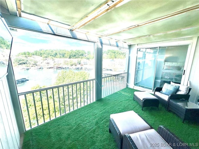 sunroom featuring a water view