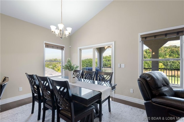 dining space with high vaulted ceiling, light hardwood / wood-style floors, and a notable chandelier