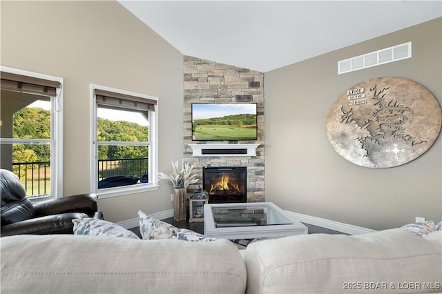 living room with vaulted ceiling and a fireplace