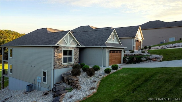 view of front of house featuring cooling unit, a garage, and a lawn