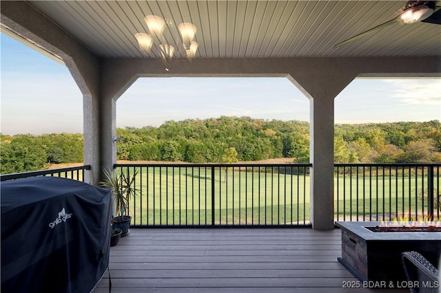 wooden deck featuring ceiling fan, a yard, grilling area, and an outdoor fire pit