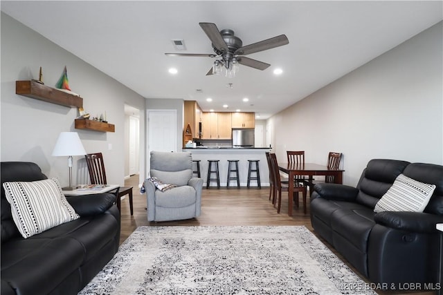 living room with wood-type flooring and ceiling fan