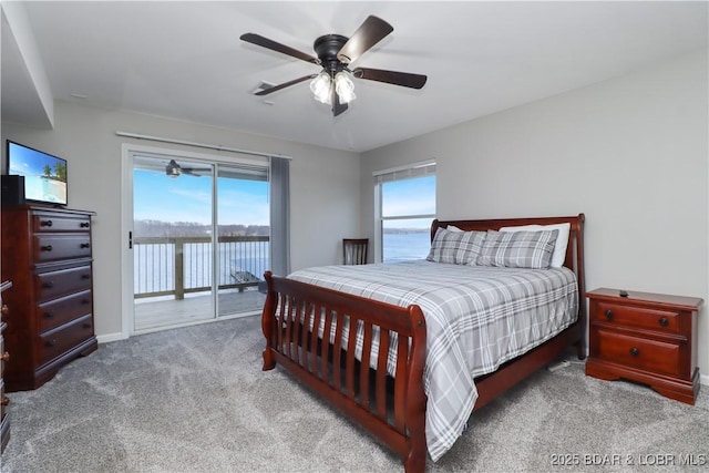 carpeted bedroom featuring a water view, access to exterior, and ceiling fan