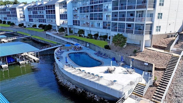 view of swimming pool with a water view and a patio area