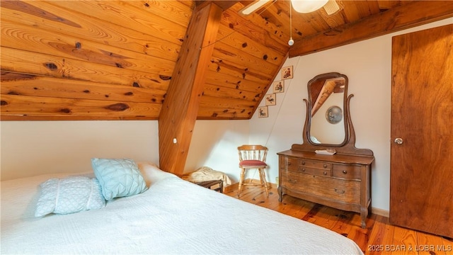 bedroom featuring hardwood / wood-style floors, wood ceiling, and vaulted ceiling with beams