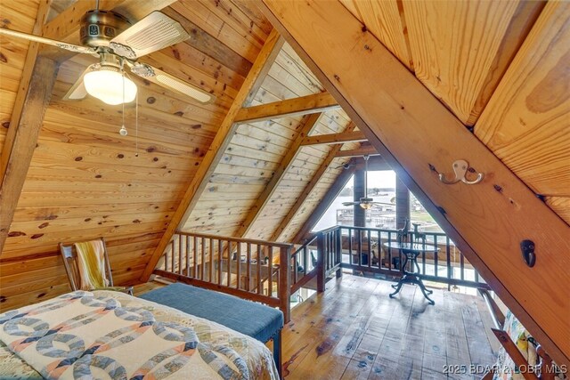 bedroom with hardwood / wood-style floors, wooden walls, lofted ceiling with beams, access to outside, and wooden ceiling