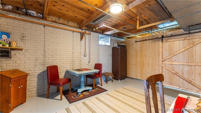 basement with brick wall and a barn door