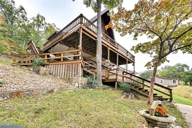 back of property featuring a yard and a deck