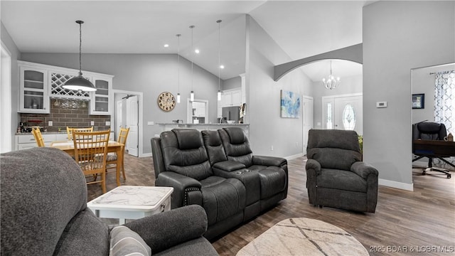 living room with dark hardwood / wood-style floors, an inviting chandelier, and high vaulted ceiling