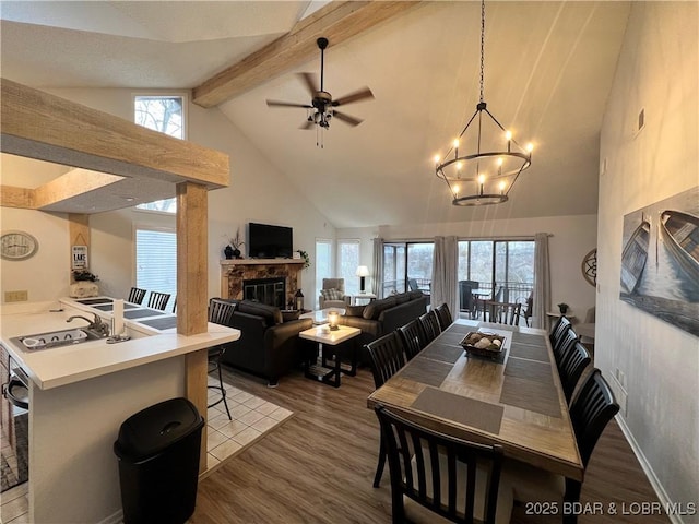 223 Waterscape Dr, Osage Beach, MO 65065 - dining area featuring a fireplace, wood finished floors, high vaulted ceiling, a chandelier, and beamed ceiling