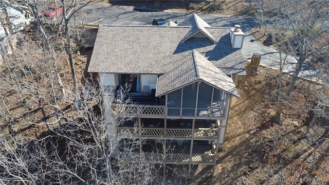 back of house with roof with shingles