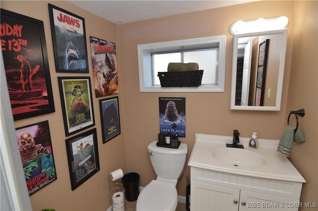 bathroom featuring vanity, toilet, and a textured ceiling