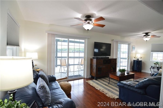 living room featuring dark wood-type flooring and ceiling fan