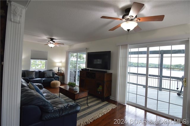 living room with hardwood / wood-style flooring, ceiling fan, and a textured ceiling