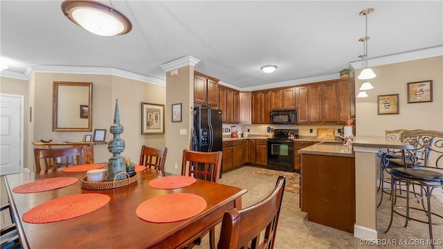 kitchen featuring pendant lighting, sink, crown molding, black appliances, and kitchen peninsula