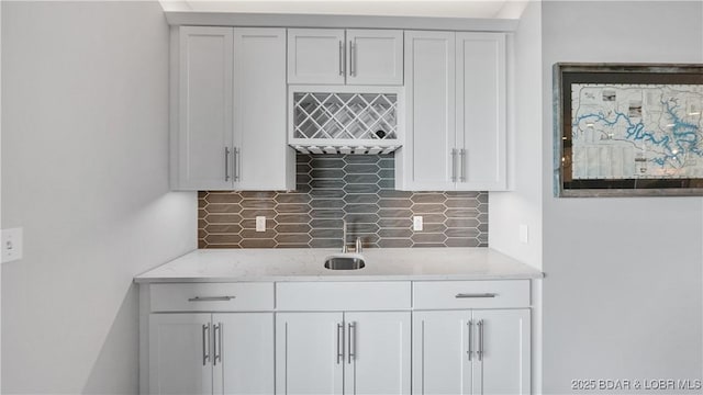 bar with light stone counters and white cabinets