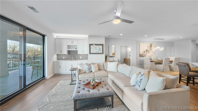 living area featuring light wood finished floors, visible vents, a ceiling fan, and recessed lighting