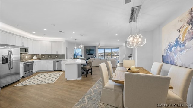 dining space featuring ceiling fan and light hardwood / wood-style flooring