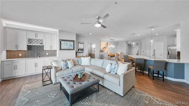 living room featuring indoor wet bar, dark wood-type flooring, and ceiling fan