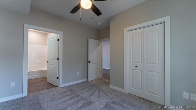 unfurnished bedroom featuring light carpet, connected bathroom, a closet, and ceiling fan