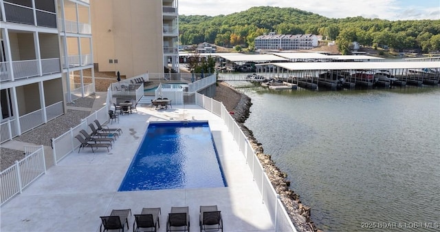 view of swimming pool featuring a patio area and a water view